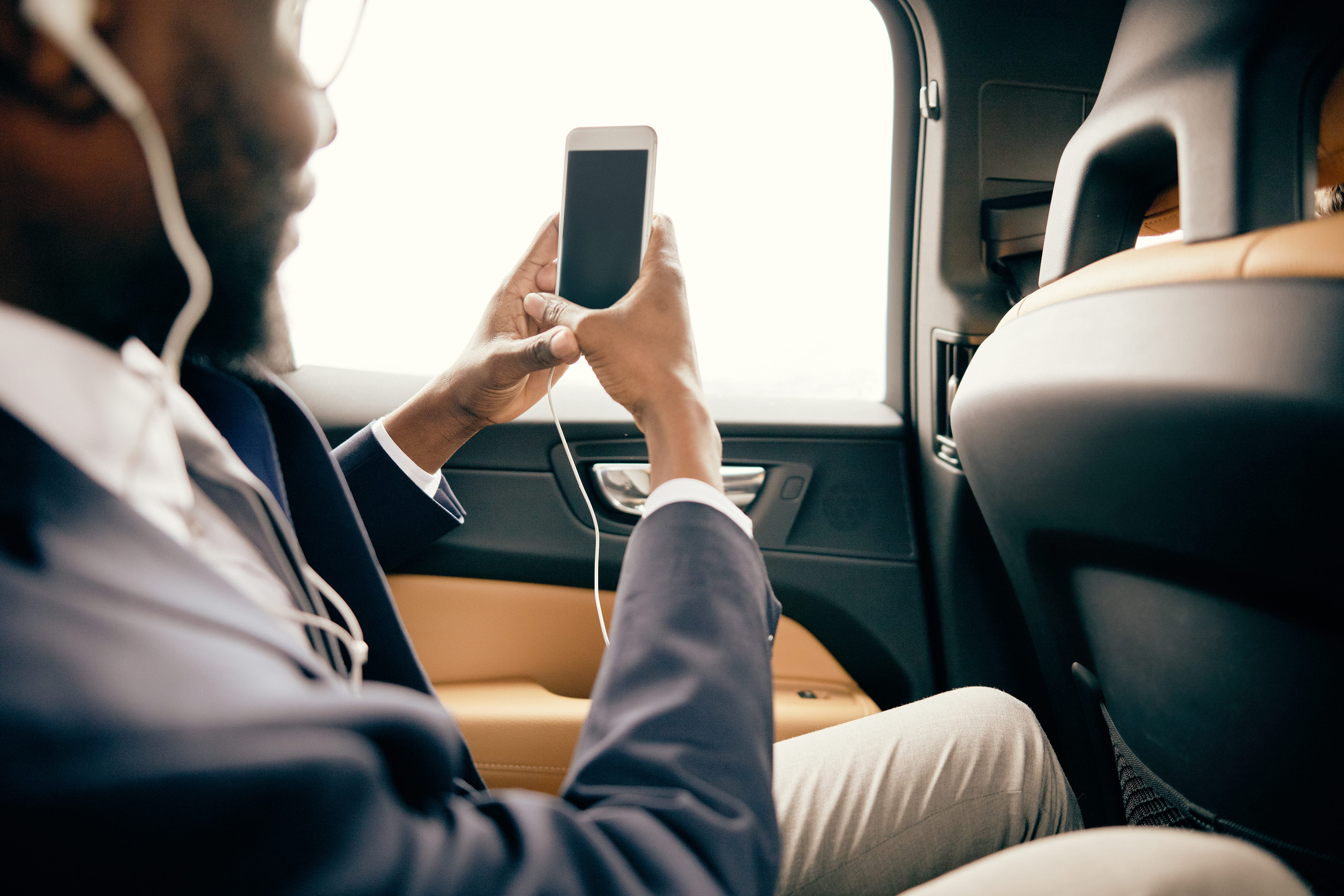 Man taking photos from inside the car with his headphones on.