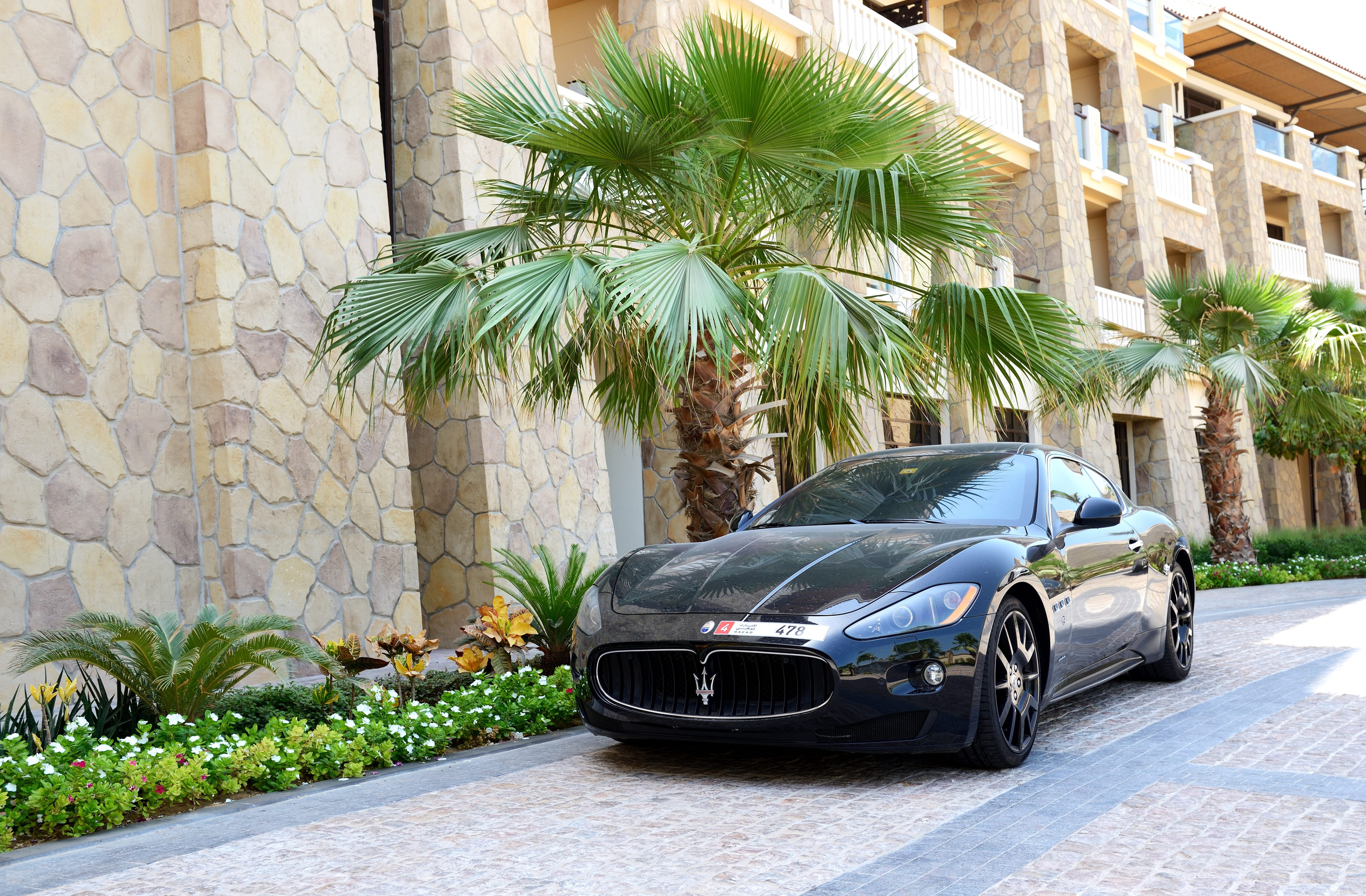 DUBAI, UAE - SEPTEMBER 9: The luxury Maserati Granturismo car is near luxurious hotel on September 9, 2013 in Dubai, United Arab Emirates. Hotels in Dubai attracted over 11 million guests in 2013.